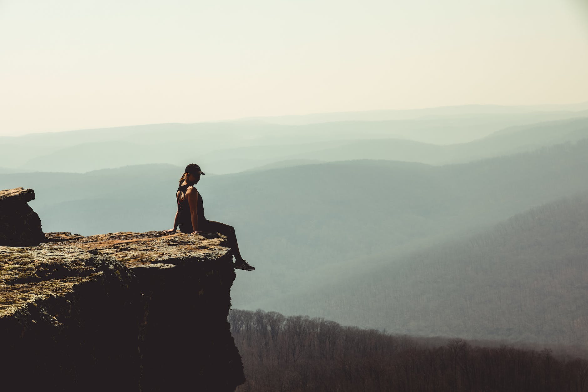 woman sitting on edge of rock formation