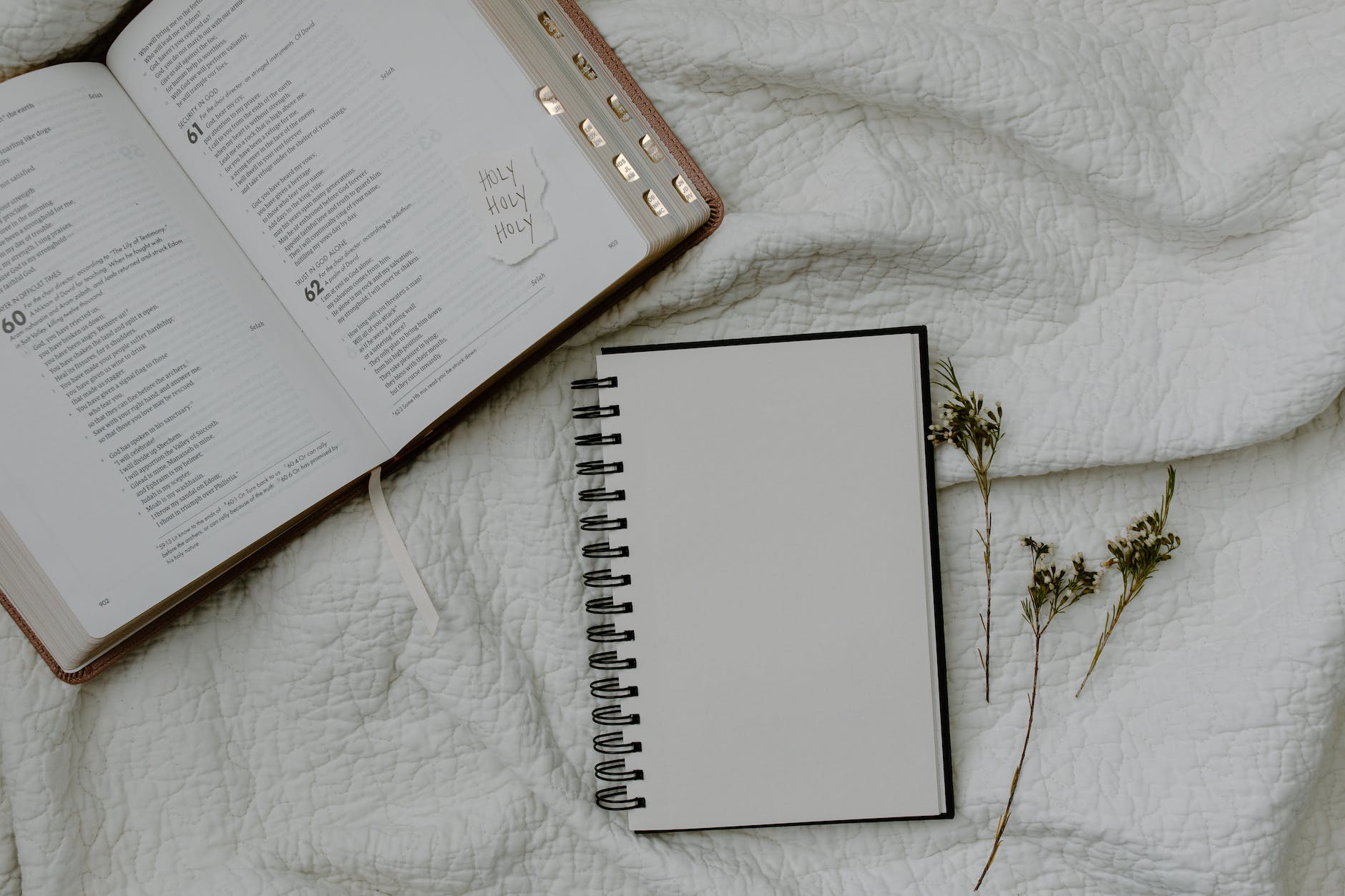 white notebook beside a bible