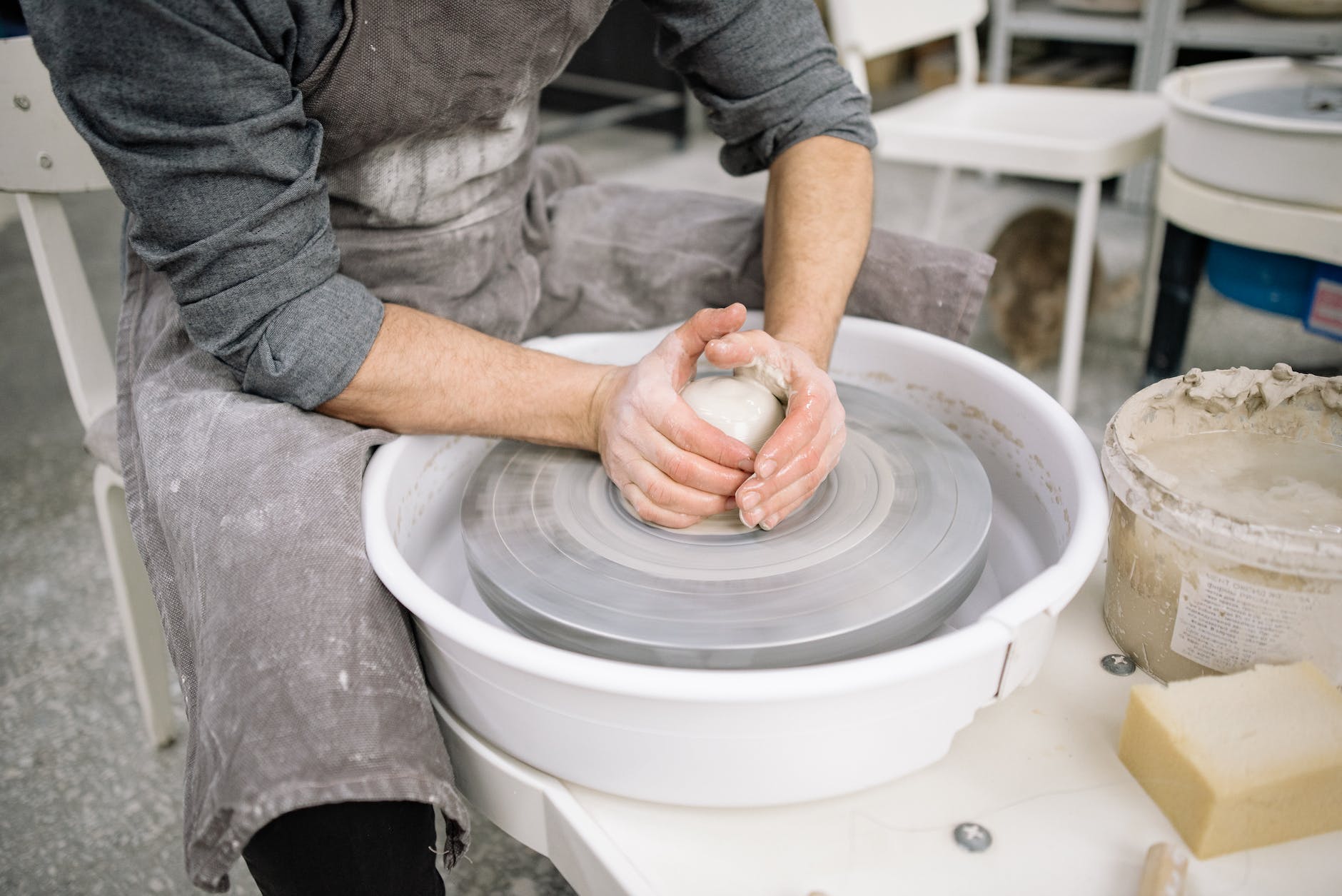 hands of a potter working with clay on a pottery wheel