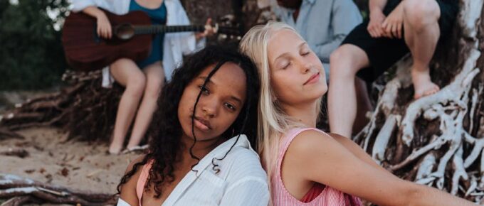 friends sitting together on the beach