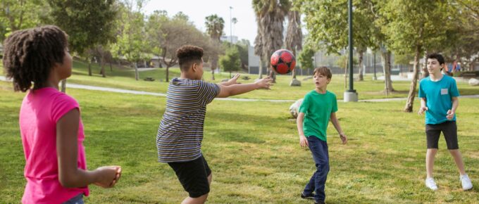 teenagers having fun playing soccer ball on a park