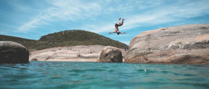 anonymous man jumping into ocean during summer vacation