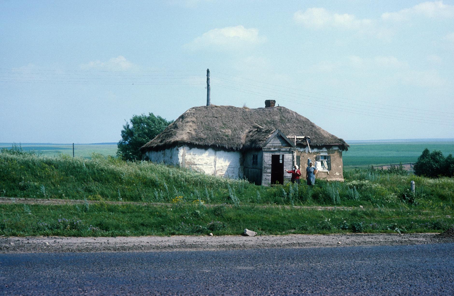 women standing by cottage in countryside