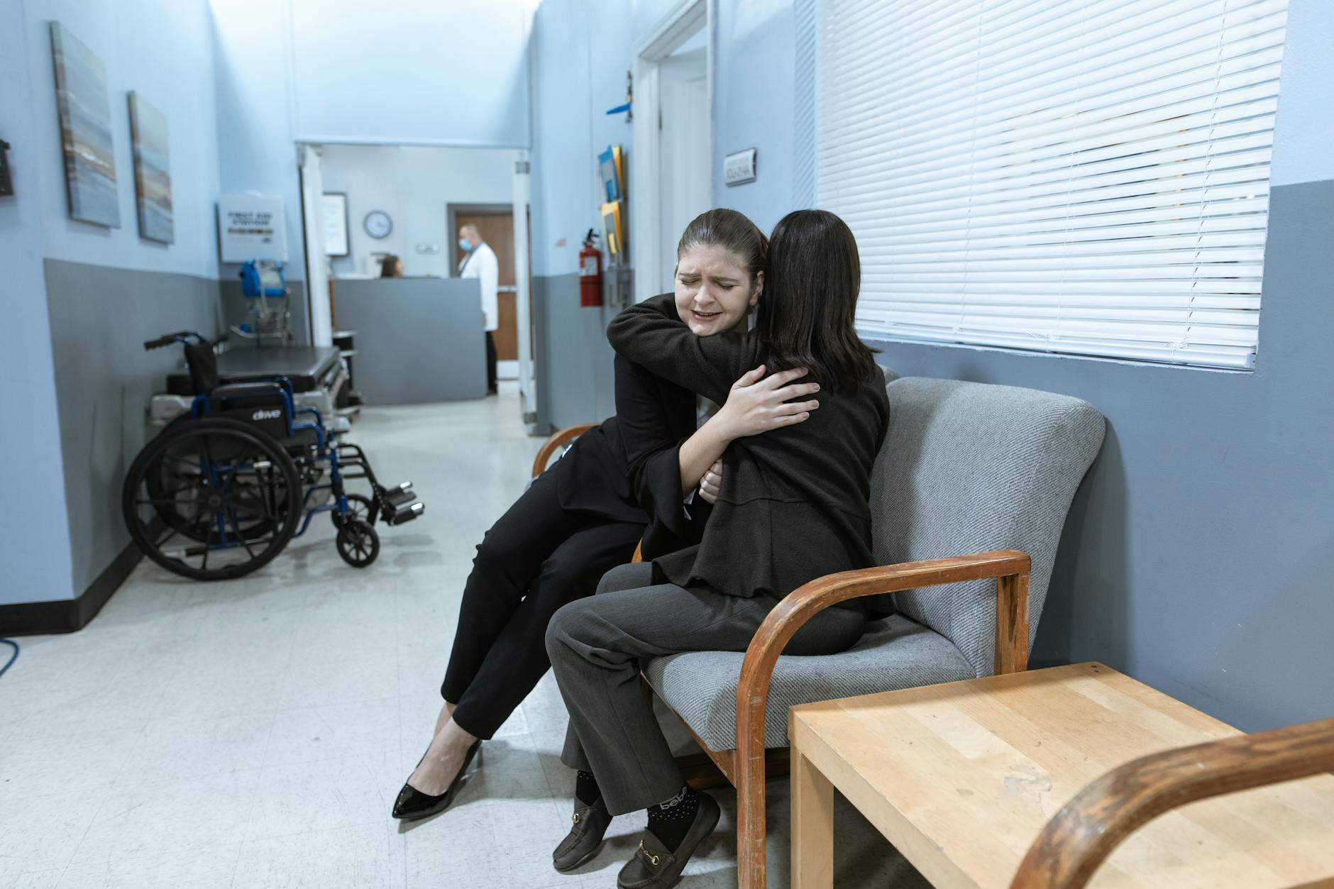 women in hugging each other while sitting on the sofa