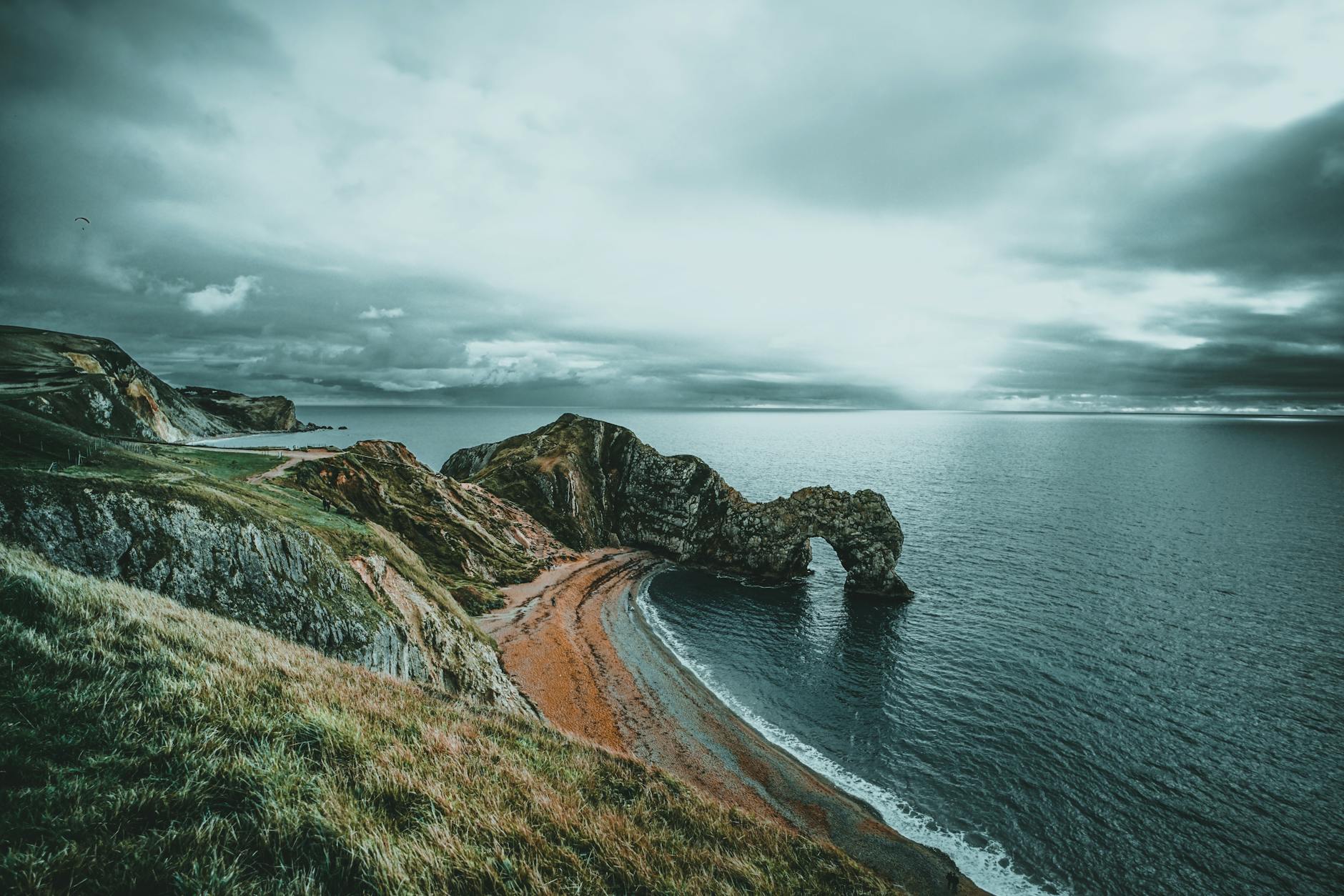 bay with orange seashore under white and gray clouds