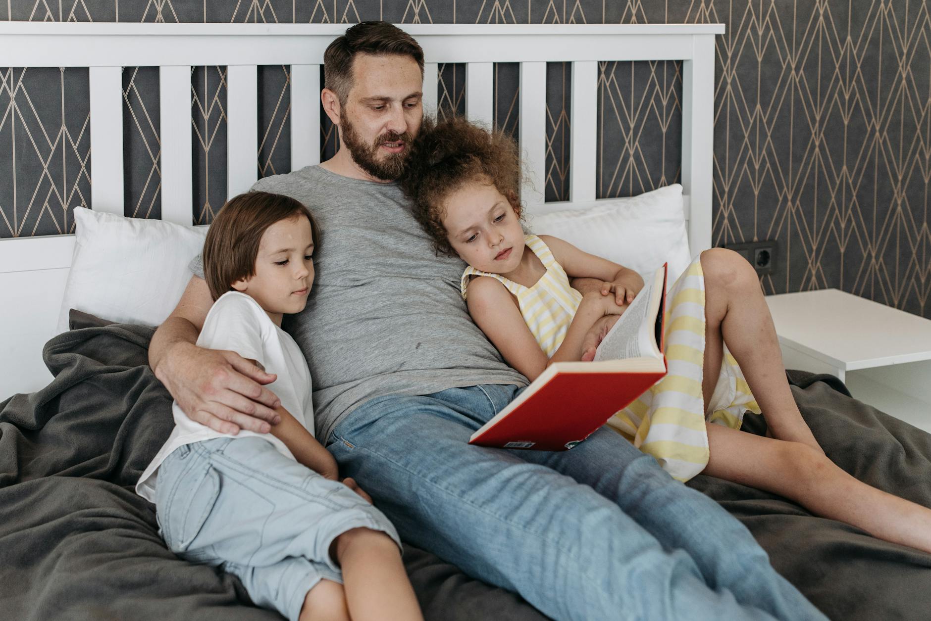 man and his children on the bed