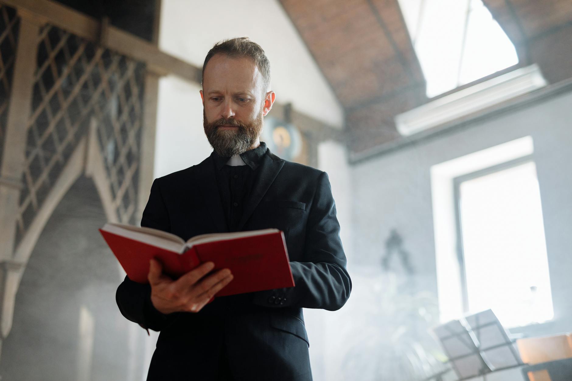 priest in church reading bible