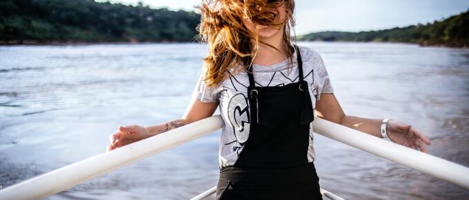 woman wearing gray shirt and black overalls on boat